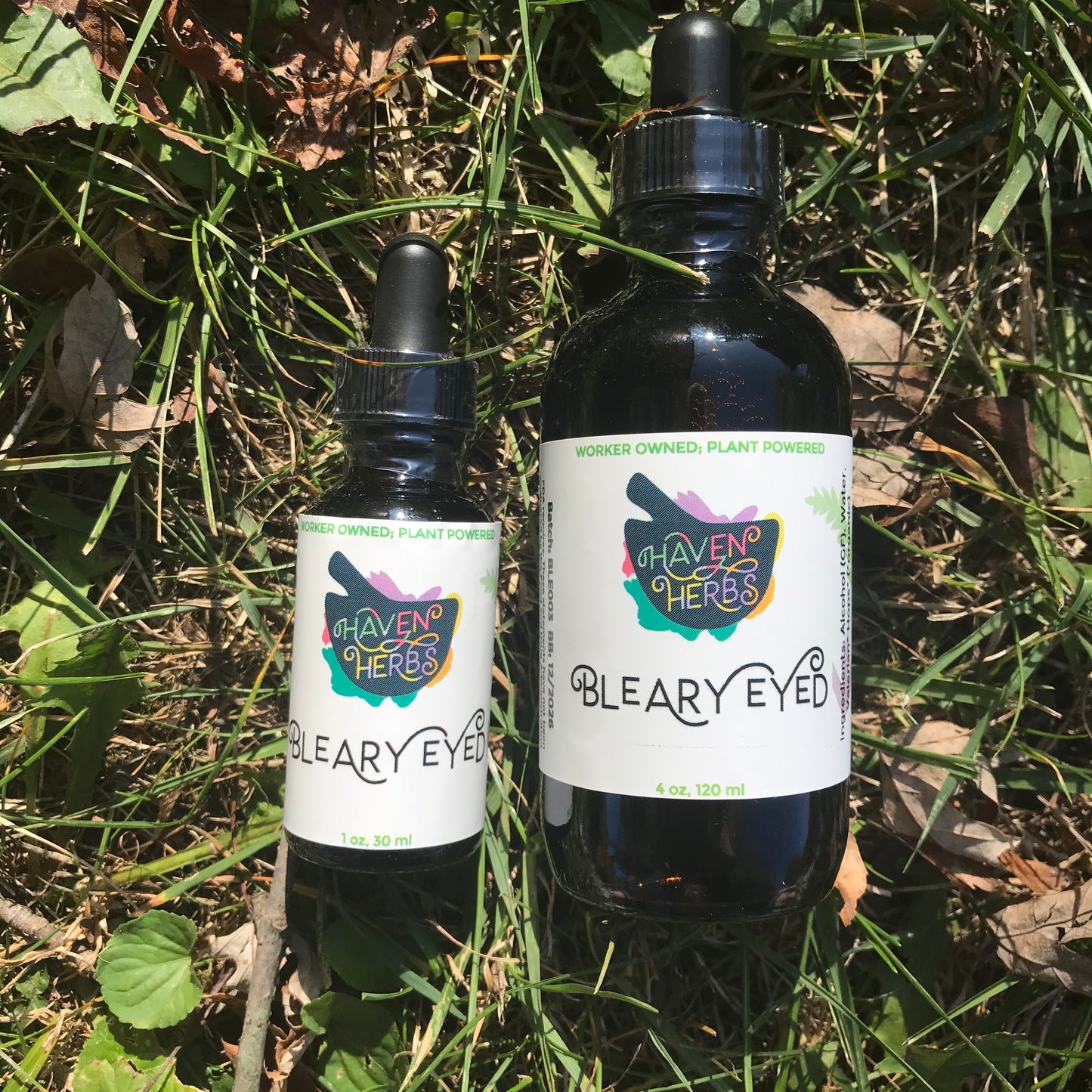 1 and 4 oz bottles of Bleary Eyed on a grass background